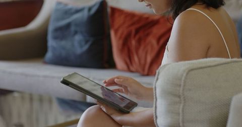 Woman Using Tablet Relaxing on Comfortable Sofa