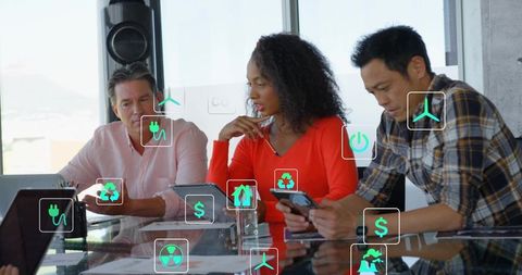 Executive team collaborating around tablet with sustainability and finance digital icons