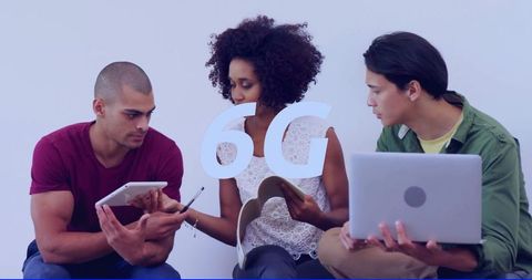 Young professionals collaborating with tablet, laptop and notebook for 6g connectivity concept