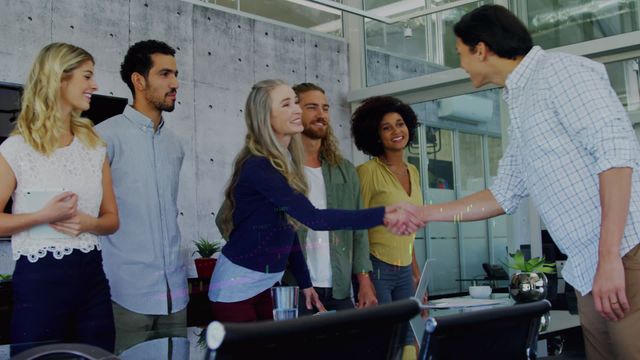 Diverse business team meeting in a modern office environment with a handshake symbolizing collaboration. Suitable for illustrating concepts of teamwork, professional collaboration, business partnerships, and startup culture in presentations, websites, marketing materials, and corporate communication.