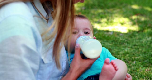 Mother Feeding Baby with Bottle in Park - Download Free Stock Images Pikwizard.com