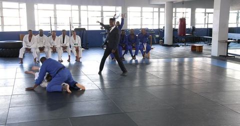 Martial Arts Enthusiasts Practicing Grappling Techniques in Leisure Center