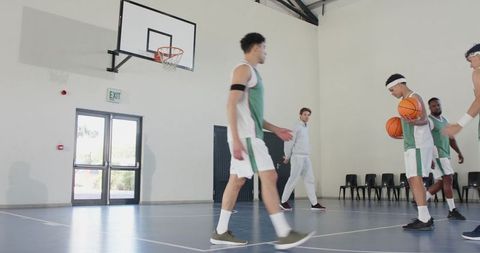 Basketball Players Practicing with Coach on Indoor Court
