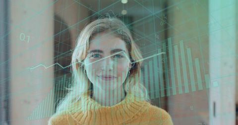 Young woman wearing earbud analyzing teal data overlay with bar and line charts