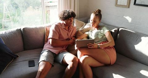 Couple Engaging Online Relaxing in Living Room