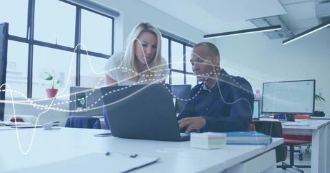 Collaborating on digital analytics with laptop in modern open office and waveform overlay