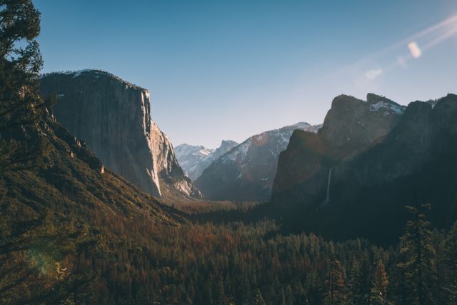 Beautiful sunrise scene over Yosemite Valley, showcasing the royal mountains and dense forest cover. This image captures a pristine, natural environment perfect for use in travel brochures, nature blogs, environmental campaigns, or decor for those that appreciate untouched wilderness.