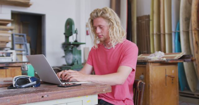 Young blonde craftsman using laptop in workshop - Download Free Stock Images Pikwizard.com