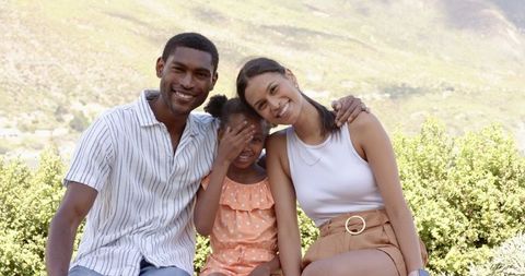 Happy Family Relaxing on Park Bench in Natural Setting