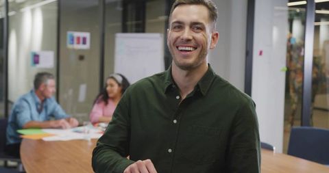 Smiling professional leading collaborative brainstorming session in modern meeting room