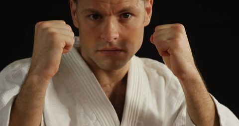 Determined Male Holding Defensive Martial Arts Pose in Gi