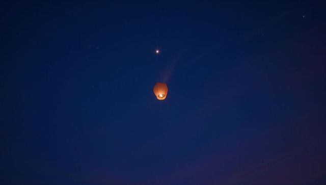 Lantern Glowing Against Night Sky with Bright Star