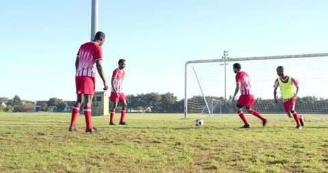 Soccer Players Practicing on Sunny Day in Red Kits