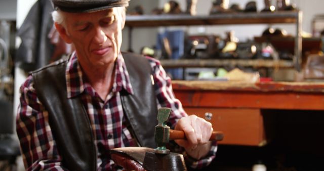 Elderly Cobbler Working on Shoe with Hammer in Workshop - Download Free Stock Photos Pikwizard.com