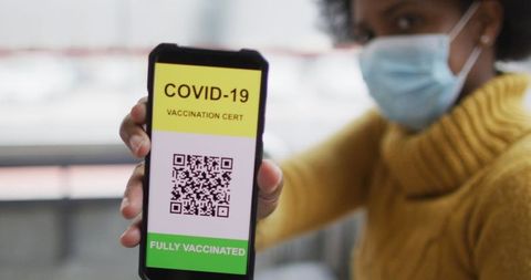 Woman displaying covid-19 vaccination certificate on smartphone