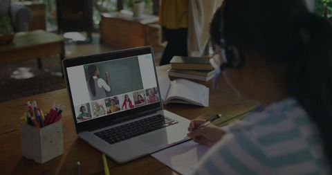 Asian Girl Engaging in Virtual Class from Home with Headset and Laptop