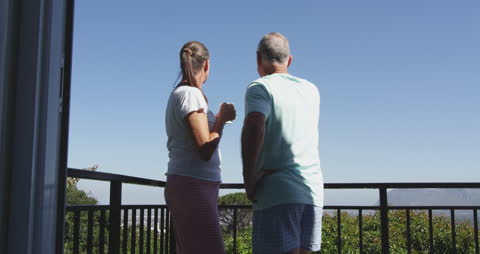 Senior Couple Enjoying Balcony View Under Blue Sky