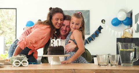 Happy family celebrating father's birthday with a cake
