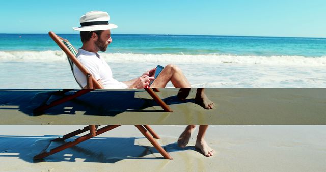 Man sits in beach chair using a tablet on a sunny day by the ocean. Perfect for concepts of relaxation, vacation, remote work, summer leisure activities, and technology use in outdoor settings.