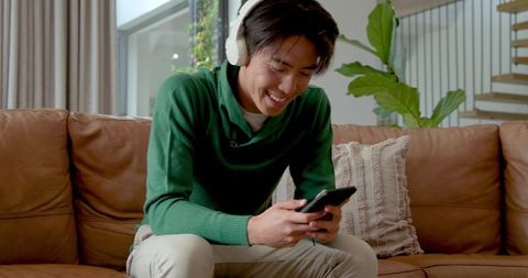 Young Man Relaxing With Headphones Checking Smartphone