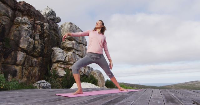 Woman Practicing Yoga Outdoors on Wooden Deck by Rocky Cliff - Download Free Stock Images Pikwizard.com