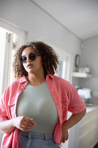 Relaxed African American Woman in Stylish Sunglasses in Modern Kitchen