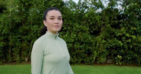 Contemplative Woman in Green Activewear Inspired by Nature