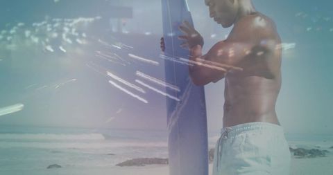 Shirtless surfer holding board on sunlit beach with waves and lens flare