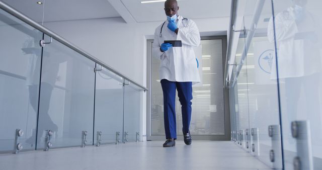 Confident African American Doctor Reviewing Patient Files in Modern Hospital - Download Free Stock Images Pikwizard.com