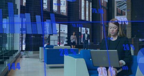 Businesswoman in Modern Lobby Analyzing Data on Laptop with Overlay Graphics