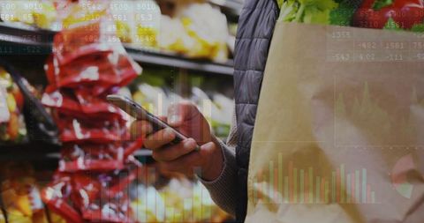 Man checking smartphone while grocery shopping holding bag of lettuce with data overlay
