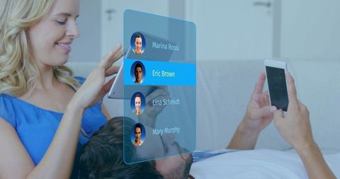 Couple using tablet and phone with holographic contact list highlighting Eric Brown