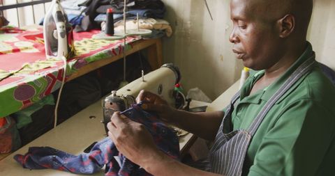 Dedicated african tailor preparing fabric in authentic workshop