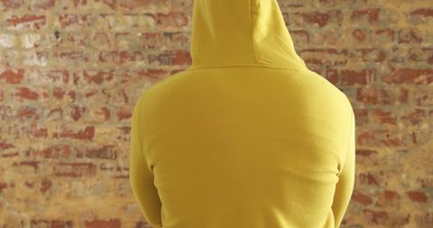 Hooded Man Standing Against Brick Wall in Urban Style - Download Free Stock Images Pikwizard.com