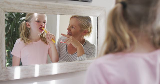 Mother and Daughter Brushing Teeth Together in Front of Mirror - Download Free Stock Images Pikwizard.com