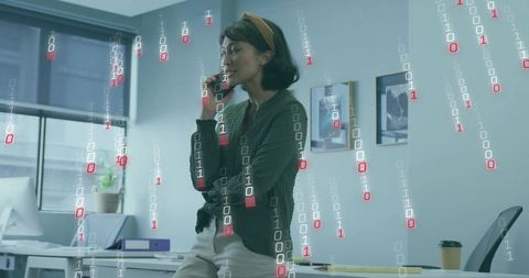 Young woman talking on smartphone with digital binary overlay in modern office workspace