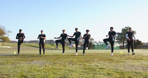 Athletes executing high-knee drills in outdoor fitness training