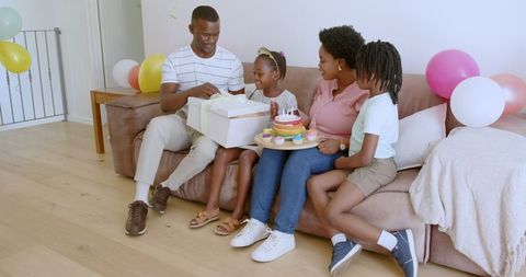 Joyful Family Celebrating Birthday with Gifts and Cake at Home
