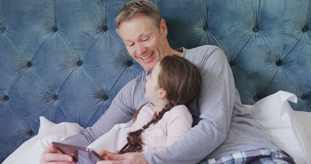 Happy Father and Daughter Enjoying Technology Together in Bed - Download Free Stock Images Pikwizard.com