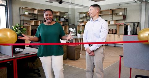 Office ribbon-cutting ceremony with happy diverse team