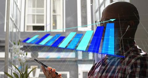 Mature professional tapping smartphone while viewing rising blue analytics chart overlay