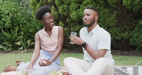 Couple enjoying outdoor picnic with drinks and snacks