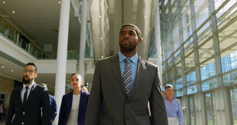 Diverse Business Team Walks Through Modern Office Lobby