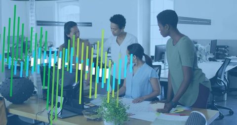 Four women collaborating around office desk reviewing design plans with colorful data overlay