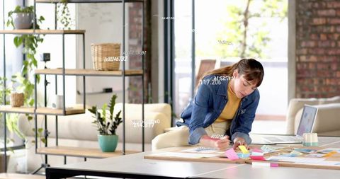 Creative professional writing sticky notes in modern coworking studio with laptop