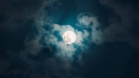 Full Moon Emerging Through Mystical Cloudscape