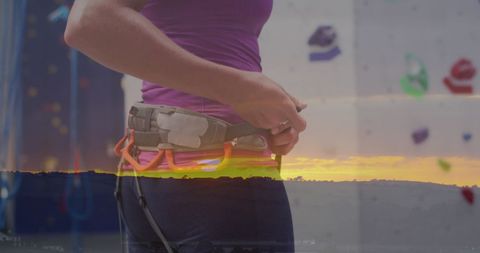 Woman rock climber preparing gear with digital overlay