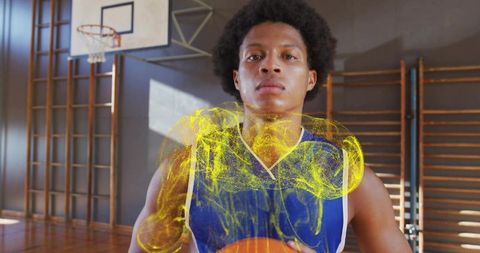 Determined Athlete Holding Basketball with Energetic Effects