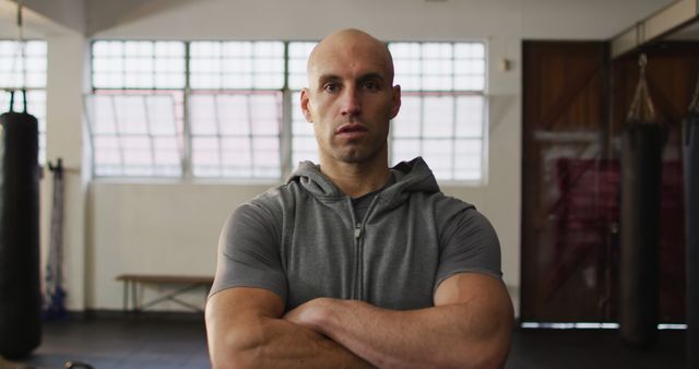 Portrait of fit caucasian man with arms crossed at the gym. sports, training and fitness concept