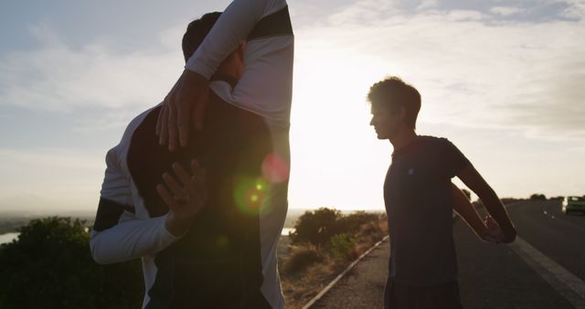 Two men stretching during outdoor workout at sunset - Download Free Stock Images Pikwizard.com